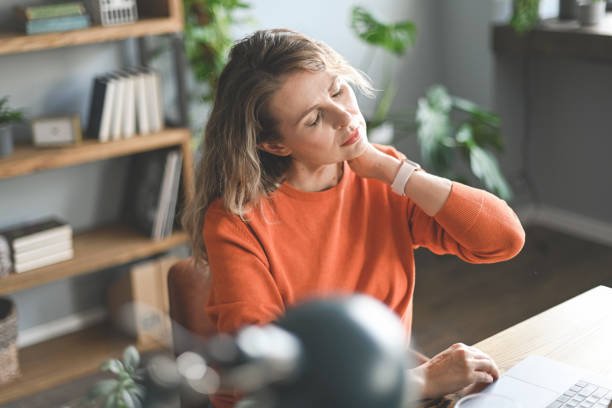Woman holding neck in pain.